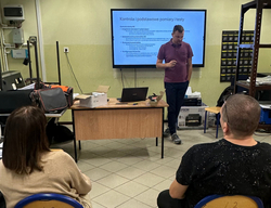 kurs systemy fotowoltaiki - prowadzący na tle prezentacji